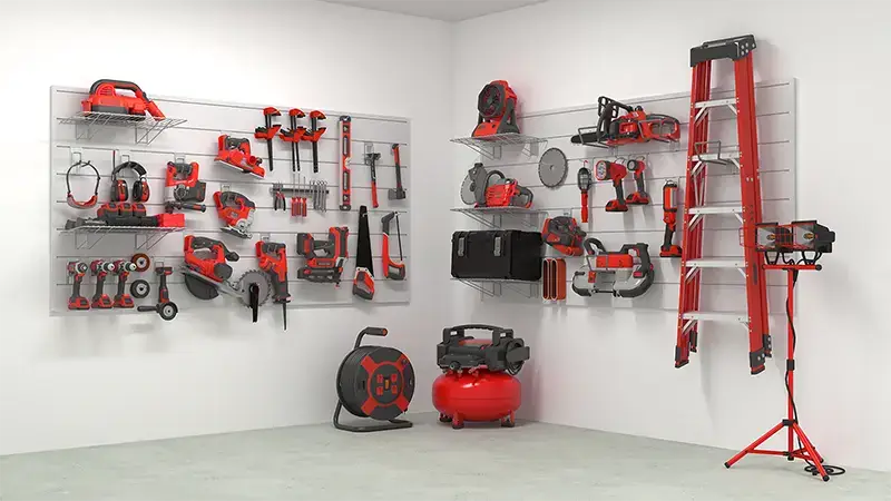 A neatly organized workshop with various red and black tools hanging on wall-mounted racks. Tools include drills, saws, wrenches, C-clamps, and an air compressor. A red ladder is leaning against the wall, and a red and black portable work light is on the floor.