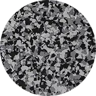 A circular image showing a random pattern of black, white, and gray paint chips or flakes densely scattered and layered, resembling a granite or terrazzo surface. The flakes vary in shape and size, creating a textured and irregular appearance.